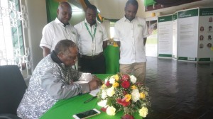 The COTU Secretary General Francis Atwoli and NSSF Board Member signing the visitors book at the ongoing Mombasa ASK Show. Standing by him are Mombasa Branch staff.